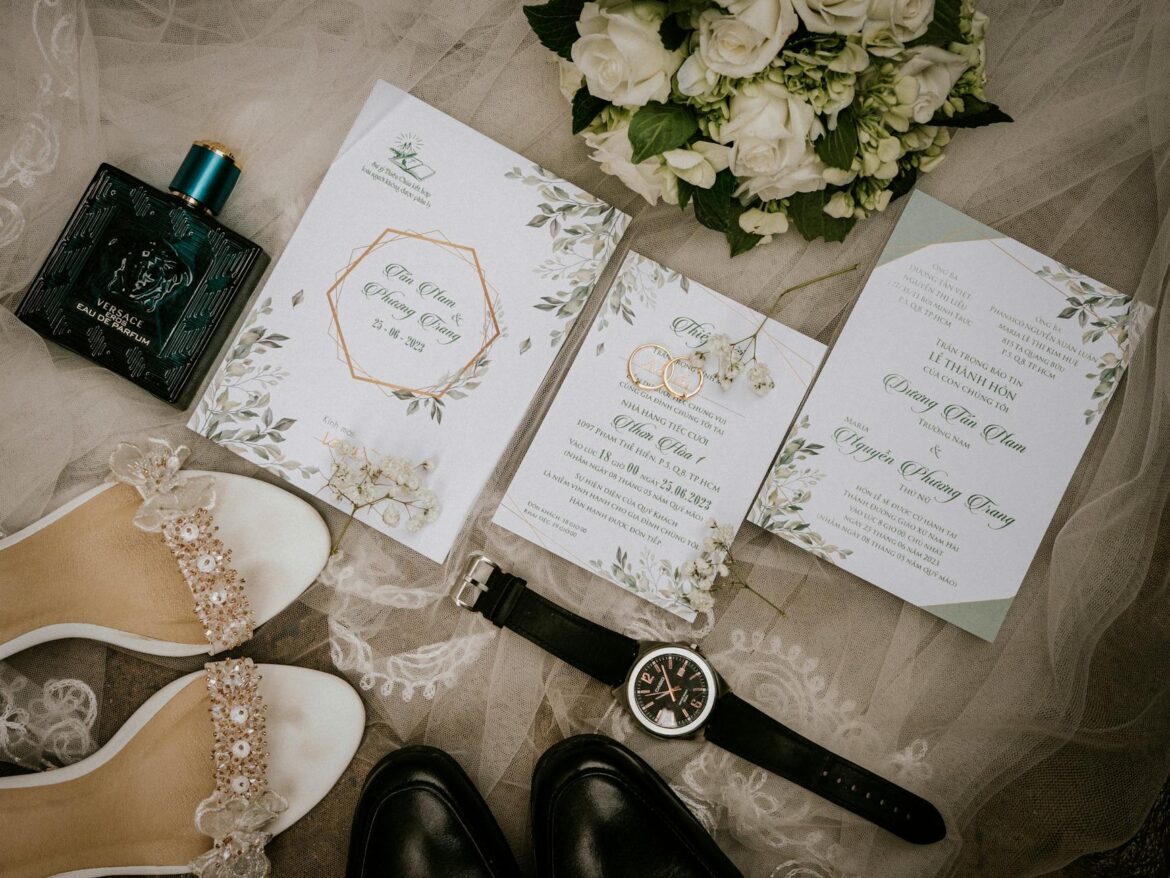 top view of wedding rings lying on cards among items worn by bride and groom